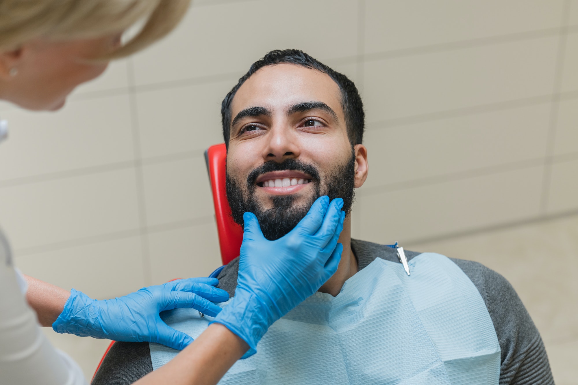 Man with perfect ideal smile visiting dentist orthodontist for veneers implantation